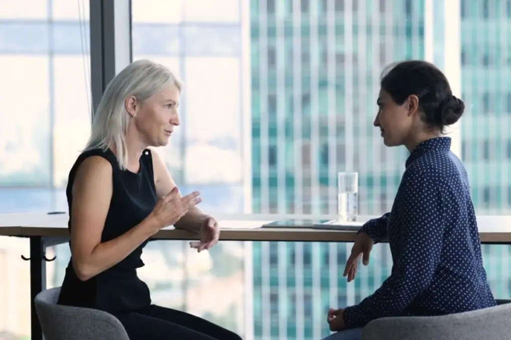 Better Questions - Leader having a one-on-one conversation with an employee in a modern office