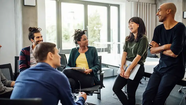 Team members engaged in a collaborative workplace discussion during a leadership meeting