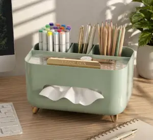 Mint green desktop organizer with tissue box, pens, markers, colored pencils, and office supplies on a modern wooden desk.
